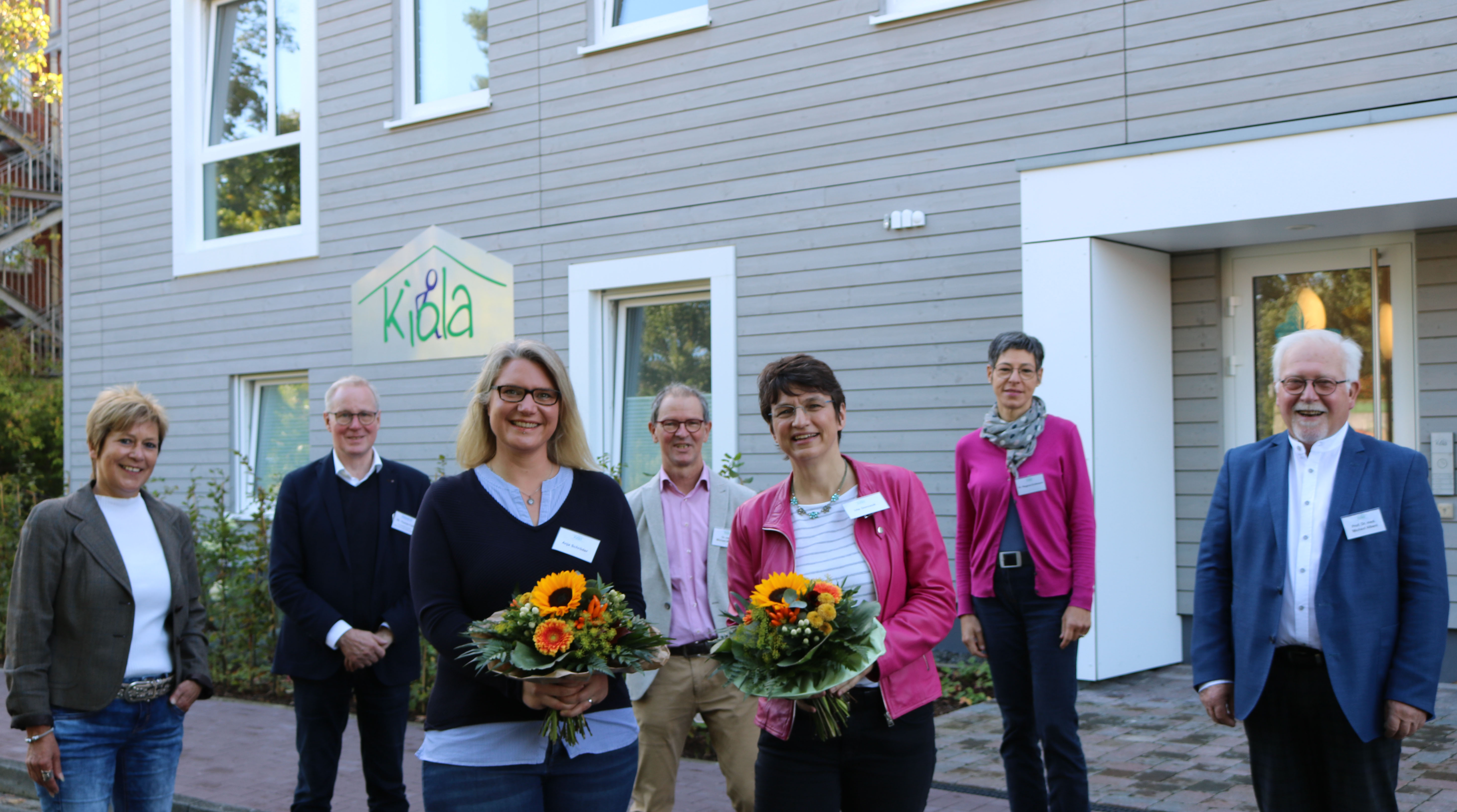 Koordinatorin Anja Schröder (1. Reihe von links) und Einrichtungsleiterin Ute Dorczok freuen sich mit Bürgermeisterin Christine Wolf (2.Reihe von links), Diakonie-VorstandThomas Feld sowie den Kiola-Vorstandsmitglieder Dr. Michael Wagner, Dr. Regina Erdmann und Prof. Dr. Michael Albani über die offizielle Eröffnungsfeier im KIOLA-Haus. Foto:Kerstin Kempermann